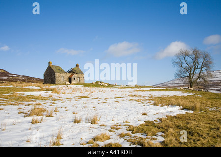 Deserted and abandoned derelict ruined farmhouse, one storey homes on moorland in winter snow northern Pitlochry Scotland UK Stock Photo
