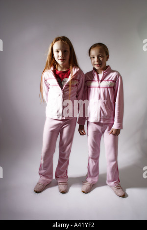 Young twin girls aged 10 standing upright confidently smiling towards the camera Stock Photo