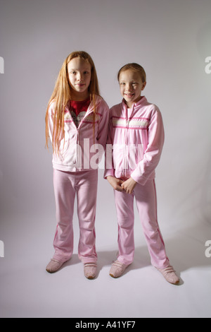 Young twin girls aged 10 standing upright confidently smiling towards the camera Stock Photo