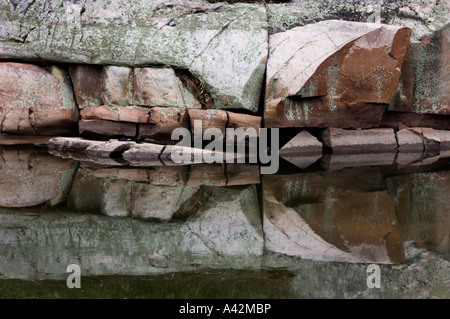 Rock outcrops reflected in Chikanishing Creek, Killarney Provincial Park, Ontario, Canada Stock Photo