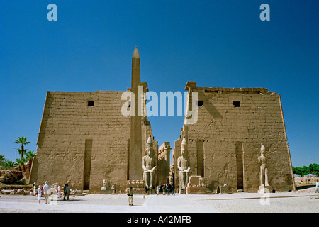 The magnificent Temple of Luxor with colossal statues of Ramses ll and an obelisk in front of the entrance pylons Stock Photo