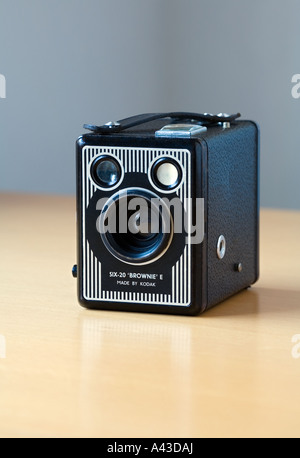 Vintage Kodak Box Brownie camera studio shot on a clean, shiny, reflective birch wood table and clean grey background. Stock Photo