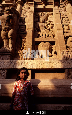 Young girl stands next to a carved wall at the Kanchi Kailasanathar Hindu temple dedicated to the Lord Shiva in Kanchipuram or Kanchi Tamil Nadu India Stock Photo