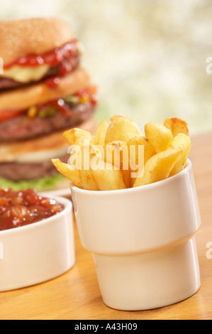 TRIPLE BEEF BURGER WITH CHEESE RELISH PICKLE SALAD ONION RELISH AND CHIPS Stock Photo