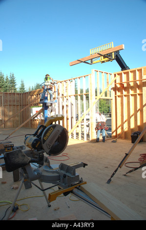 Construction - Wood Beam On Fork Lift, Workmen Preparing Installation, Saw In Foreground Stock Photo