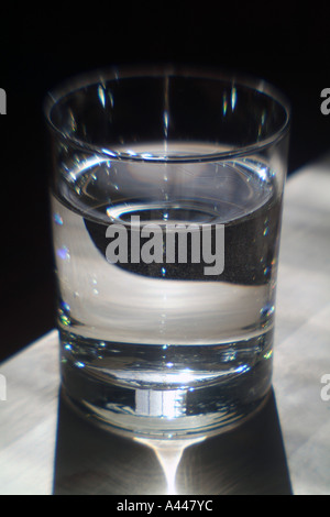 Simple glass of water on a table edge Stock Photo