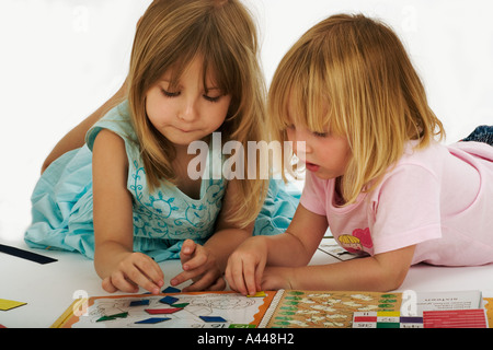 Children 2 Sisters playing with educational games Models Released Studio shot Stock Photo