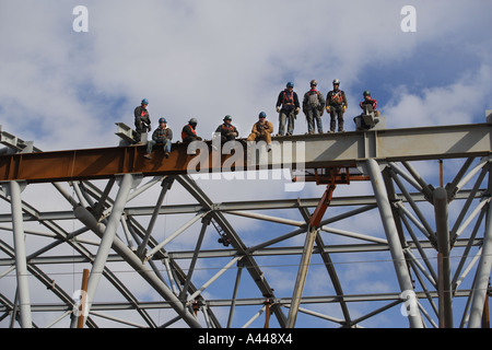 Iron Workers stand on a beam Stock Photo