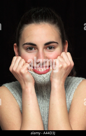 Portrait of smiling young woman with head in hands Stock Photo