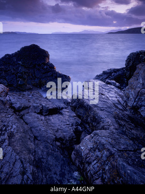 Dark skies over the rocky shore at Ardmucknish Bay, Benderloch Stock Photo