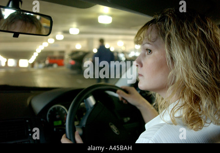 Royalty free photograph of British woman driver looking for parking space in car park London UK Stock Photo