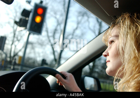 Royalty free photograph of British woman driver waiting at red lights in the rush hour London UK Stock Photo