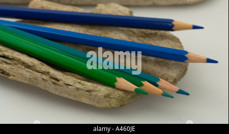 Blue and green pencils on driftwood Stock Photo
