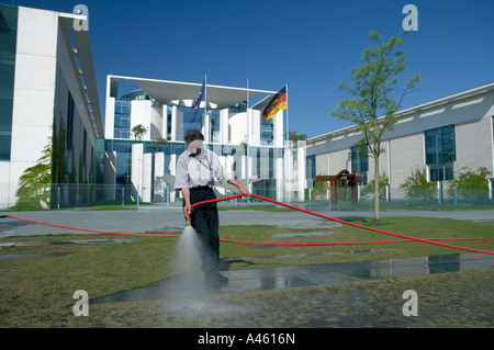 Man watering the lawn in front of the Federal Chancellery Building in Berlin, Germany Stock Photo