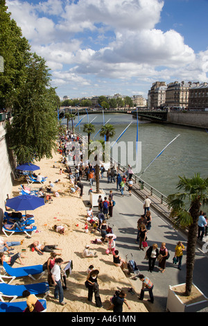 FRANCE Ile de France Paris Plage Urban Beach People walk on Voie Georges Pompidou between sand and River Seine by Ile de la Cite Stock Photo