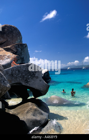 British Virgin Islands The Baths Virgin Gorda tourists in water around large granite boulders Stock Photo