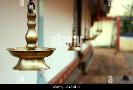 Traditional brass lamps hanging by a hindu temple in Kerala, India. Stock Photo