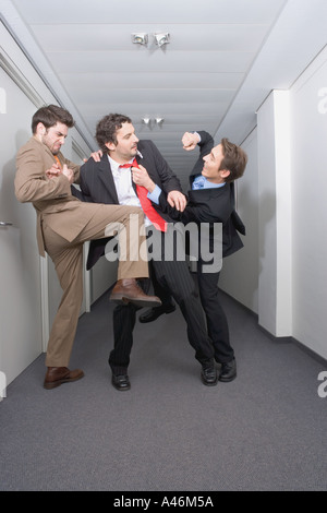 Businessmen fighting in corridor Stock Photo