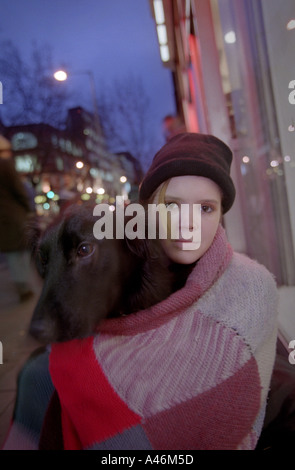 A homeless teenager sits with her dog on Charing Cross Road in London Stock Photo