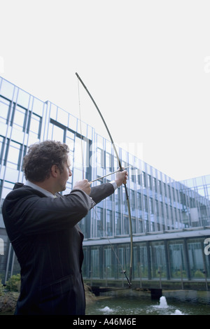 Businessman with bow and arrow Stock Photo