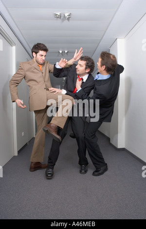 Businessmen fighting in corridor Stock Photo