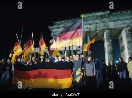 Fall of the Berlin Wall: German Reunification, cheering Berlin citizens in front of the Brandenburg Gate, Berlin, Germany Stock Photo