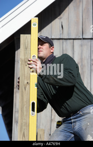 construction worker checking accuracy with a spirit level Stock Photo