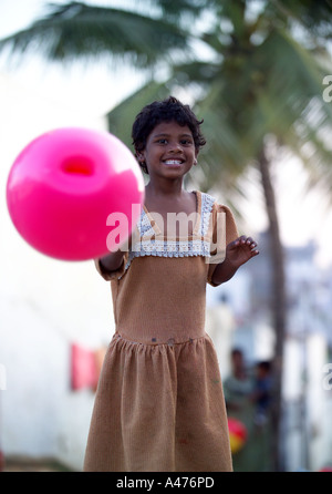 Small girl with pink balloon, playing in the street, Rupena Agrahara Hosur Road Area Bangalore, India Stock Photo