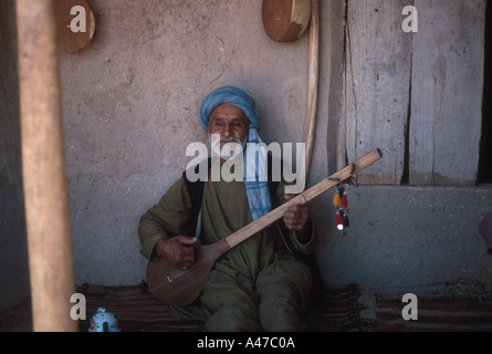 Man playing dhamboura at a chaikana teahouse Tashkurgan Khulm