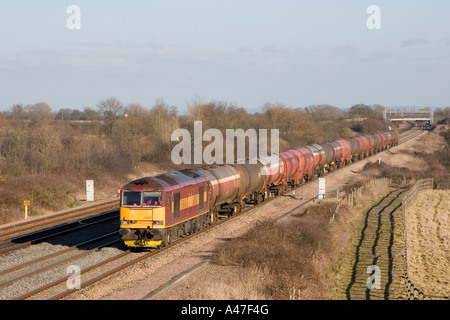 An EWS owned class 60 diesel locomotive number 60047 working a train of empty MURCO bogie oil tanks near Denchworth in Berkshire. Stock Photo