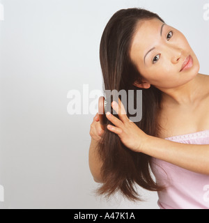 Asian woman brushing hair Stock Photo