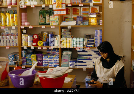 A woman shop assistant working with a calculator in a village shop in Petrovac Montenegro Stock Photo