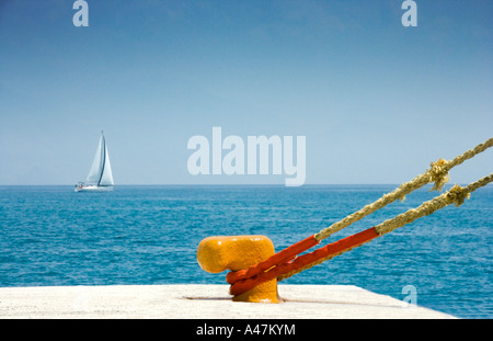 Rope tied to cleat with sailboat on Mediterranean Sea Stock Photo