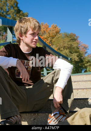 Teenage boy hanging out on steps at lakefront Milwaukee Wisconsin USA Stock Photo