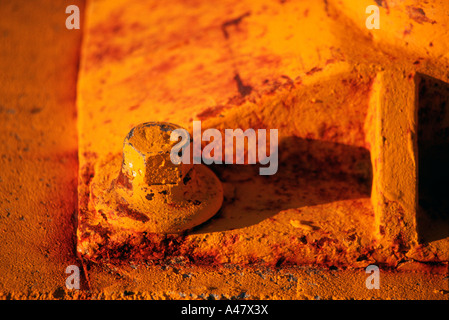 A rusty yellow bolt on a bollard Stock Photo