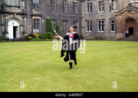 Young woman dressed in the traditional graduation gown rejoicing on graduation day at St Andrews University Stock Photo