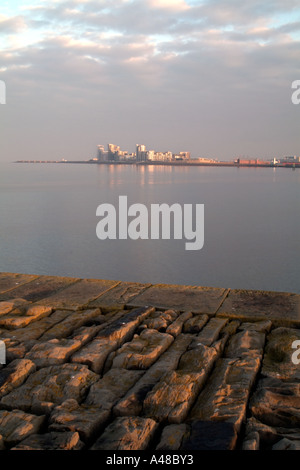 A section of the cobbled breakwater of Granton Harbour with Leith Western Harbour in the background. Stock Photo