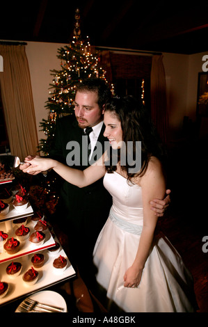 Married couple cutting wedding cake, smiling Stock Photo