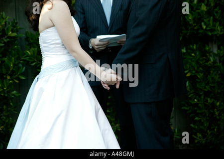 Bride and groom during marriage ceremony, mid section Stock Photo