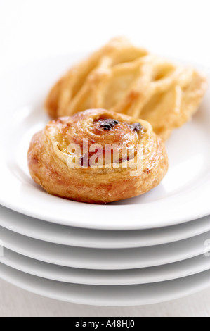 Small danish pastries on stack of white plates Stock Photo