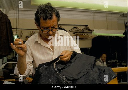 A tailor sewing up a suit in a shop in Saville Row Stock Photo