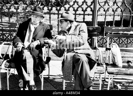 two older men talking and enjoying the spring sunshine on the esplanade beside the Danube in Budapest Stock Photo