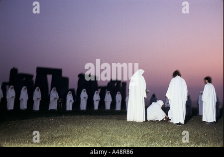 A group of Druids celebrate the rising sun during the summer solstice at Stonehenge Stock Photo