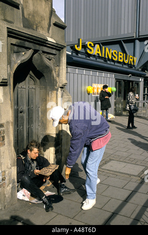 giving money to the homeless man  begging outside sainsbury's  supermarket camden town london Stock Photo