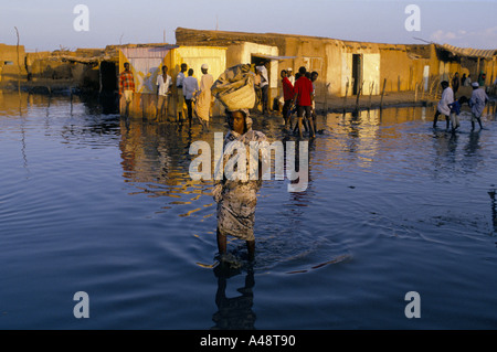 People wade through floodwater in Omdurman Khartoum after the nile burst its banks and flooded the city Stock Photo