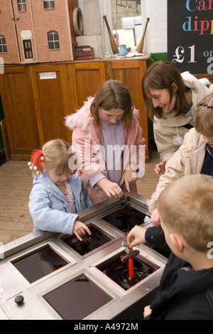 UK Shropshire Ironbridge Blists Hill museum at Christmas children making candles by dipping in hot wax Stock Photo