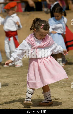 Very young Basque girl in pink dress performing traditional folk dance fiesta Andra Mari de Gorliz Basque Country Spain Stock Photo