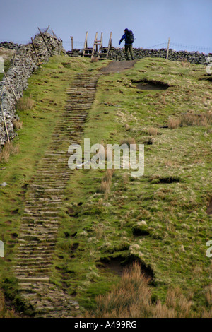 A walker at the top of a steep section of path on Pen-y-ghent Stock Photo