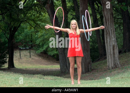 Girl twirling hoola hoops on arms Stock Photo