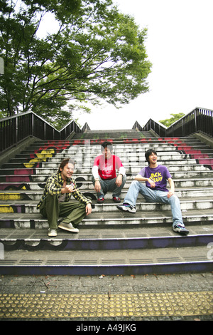 Three men sitting on steps with soccer ball Stock Photo - Alamy
